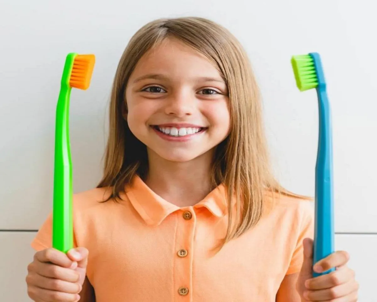 صورة لطفلة تحمل فرشاة أسنان