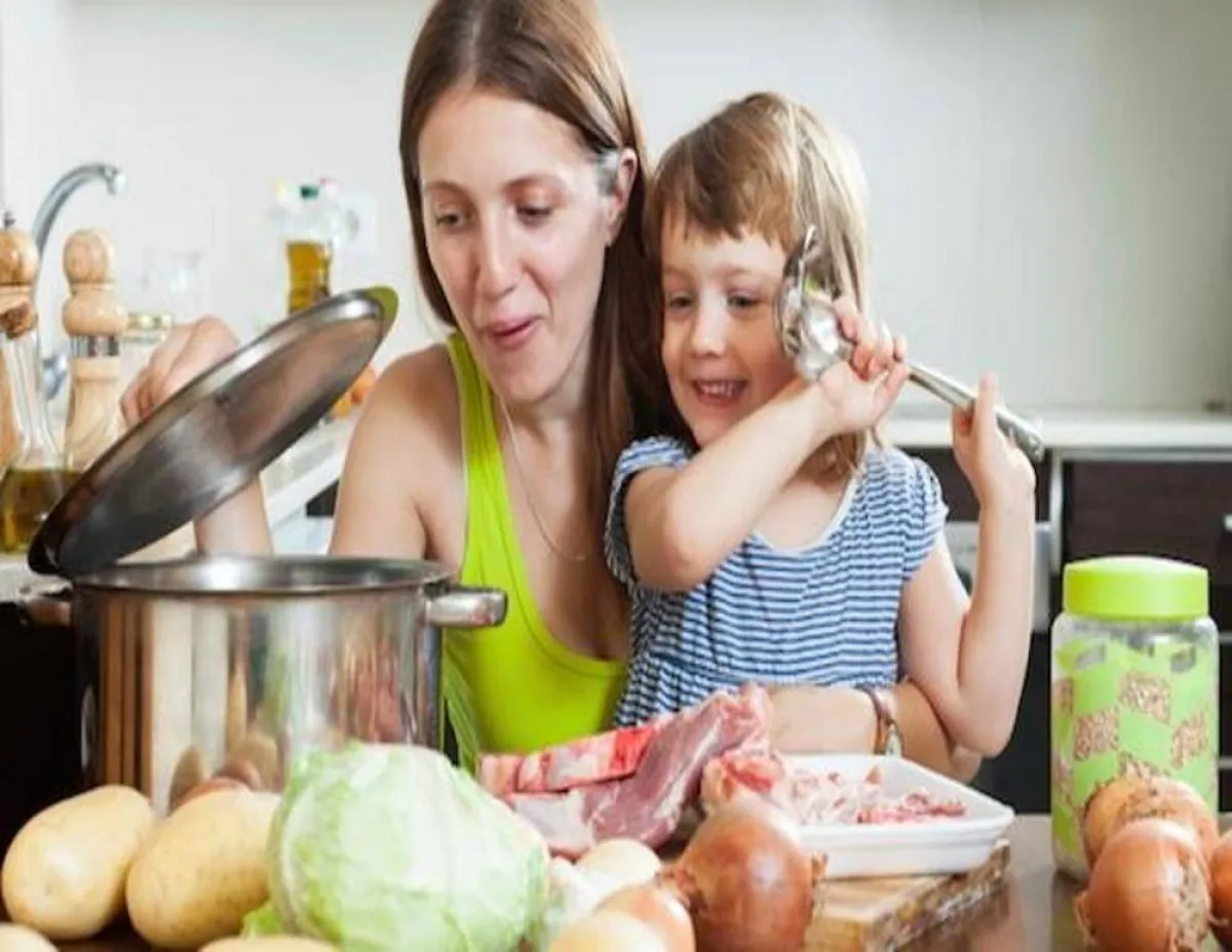 صورة لأم تحضر شوربة العدس مع طفلها