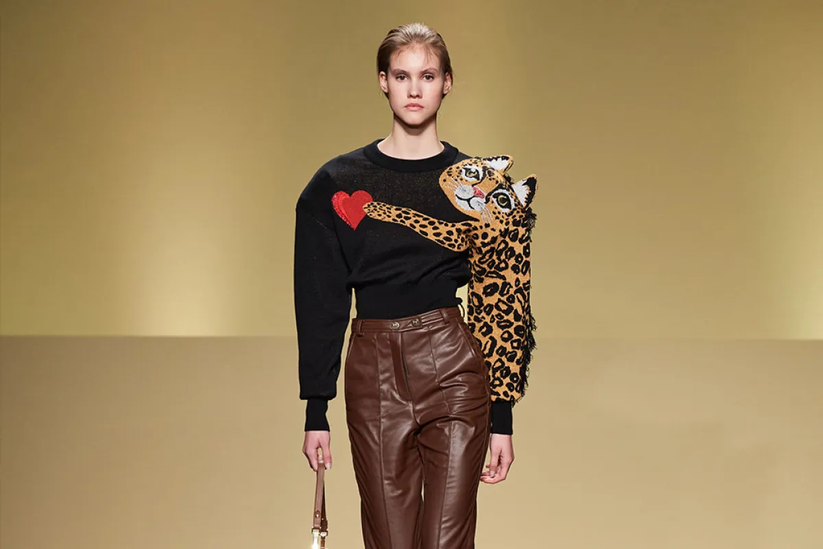 تنسيق بنطلون جلد واسع بني مع تيشرت بأكمام طويلة أسود مطبع بقطة كبيرة