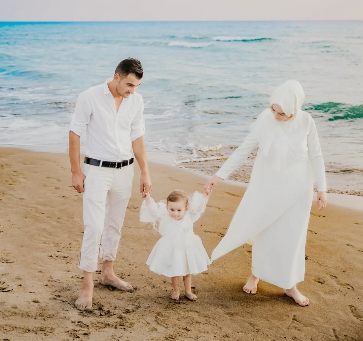 صورة لأبوين يحفزان طفلتهما على المشي