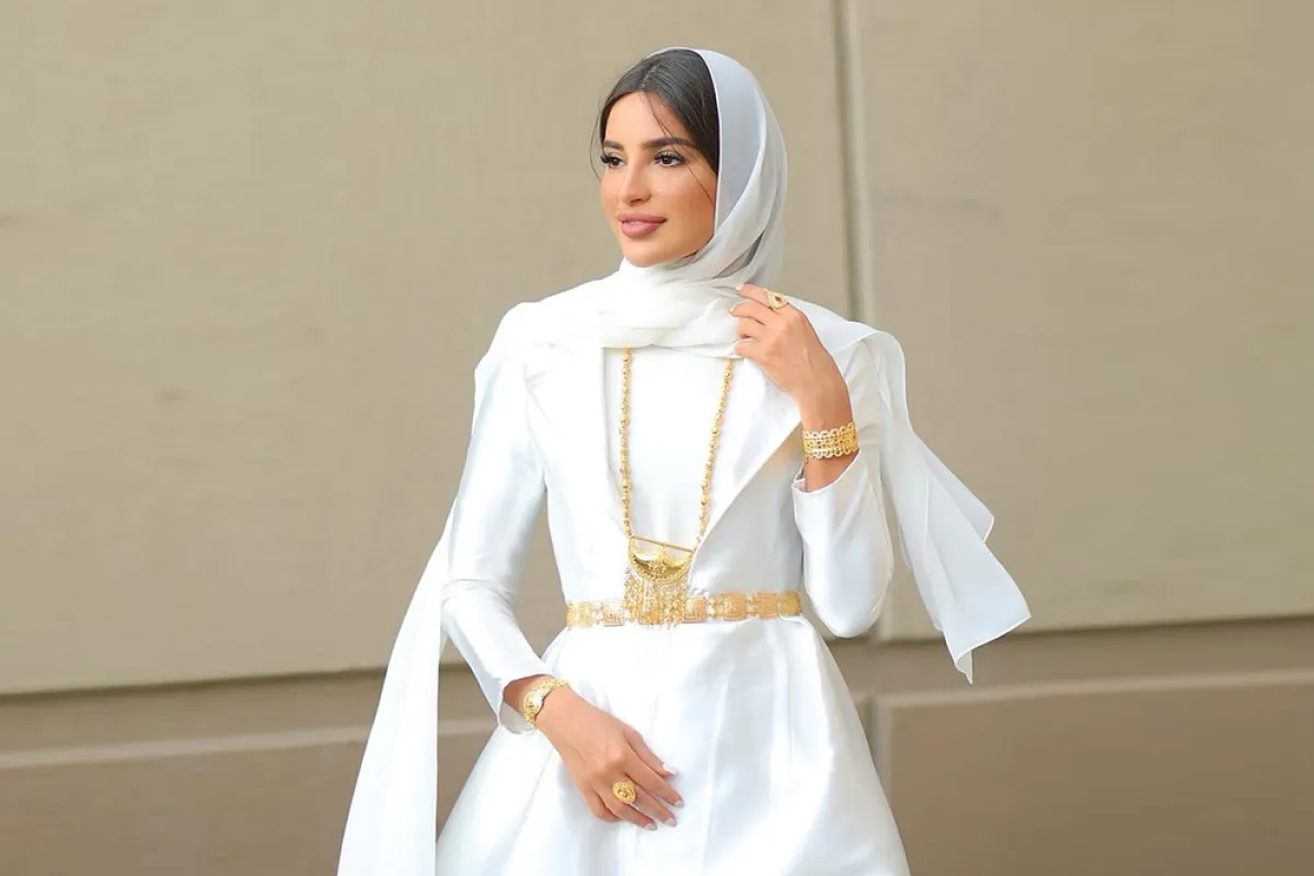 فاطمة حسام بفستان أبيض مع حزام ذهبي وإيشارب أبيض