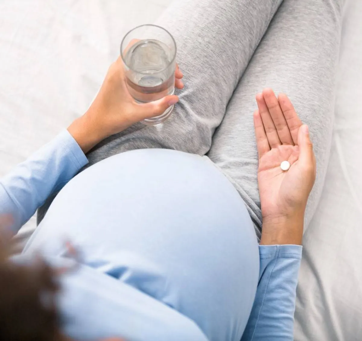 صورة لحامل تتناول المكملات الغذائية