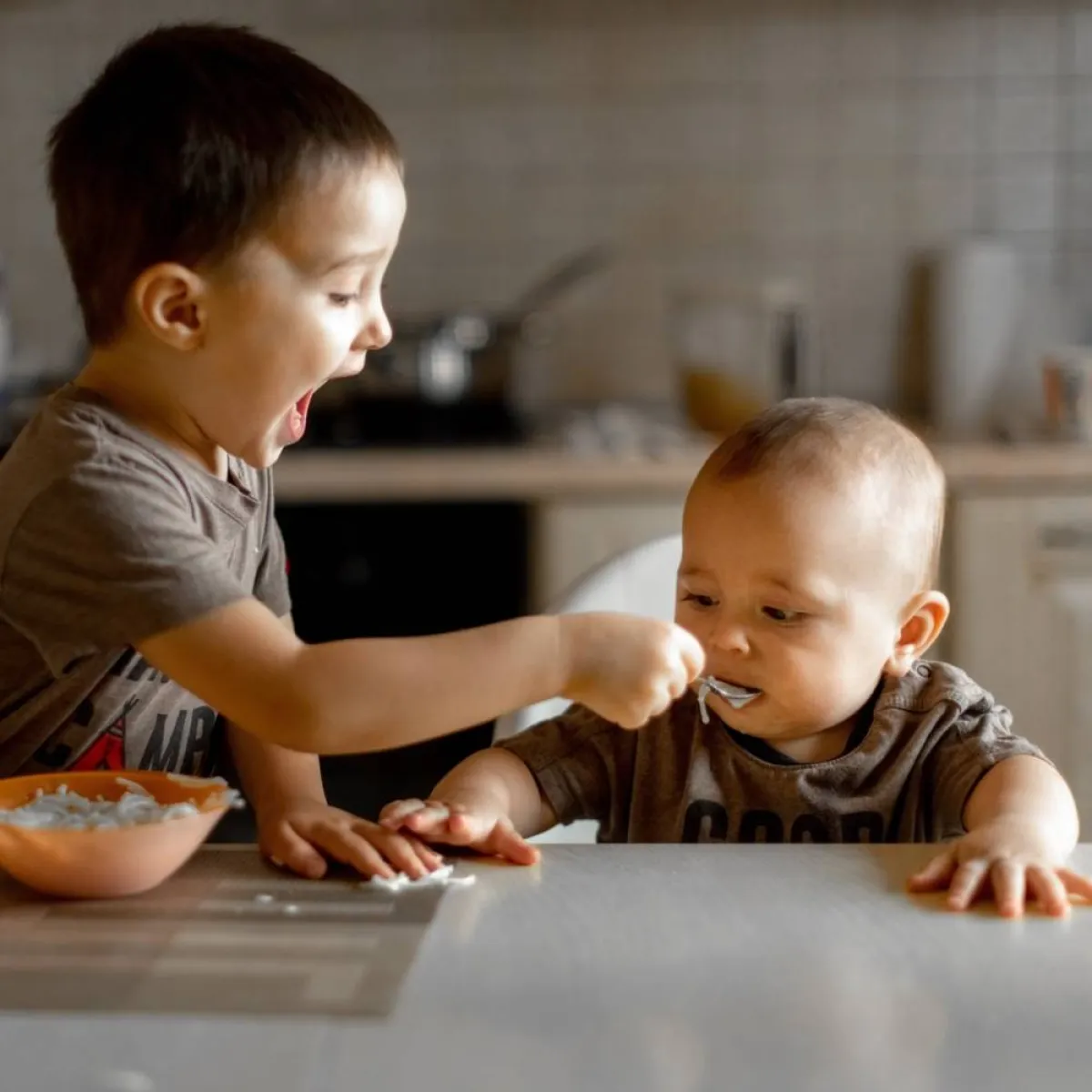 طفل يقدم الطعام لأخيه