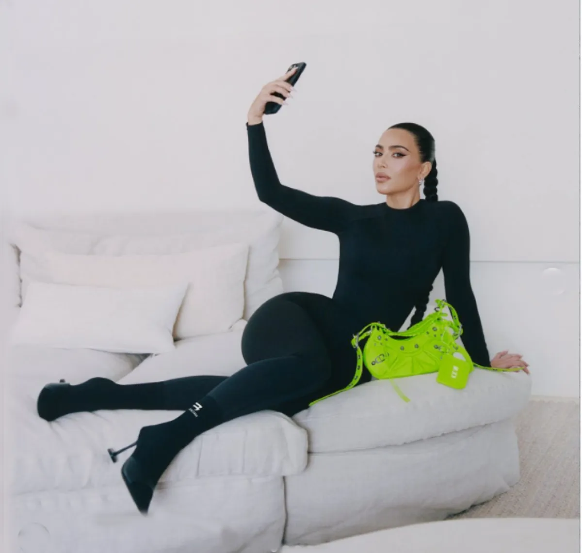 كيم كاردشيان ترتدي البزة السوداء من بالنسياغا مع حقيبة خضراء