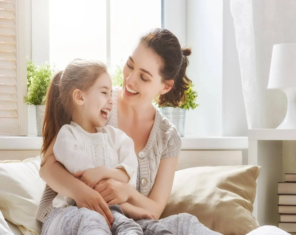 صورة لطفلة تبتسم وتتحدث مع والدتها 