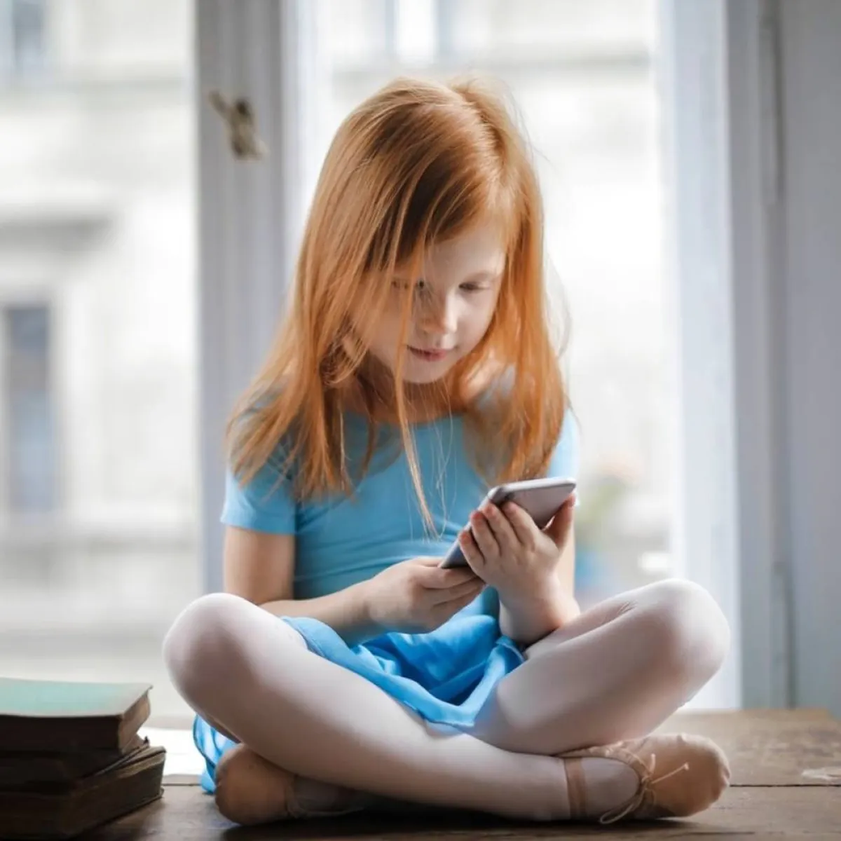 صورة لطفلة شغوفة بمتابعة الموبايل