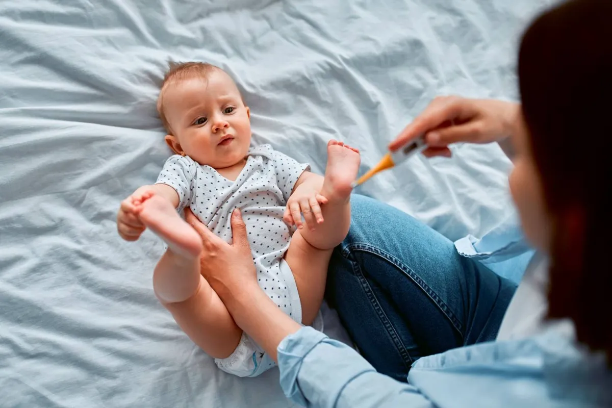 صورة أم تحصل على قراءة لحرارة رضيعها