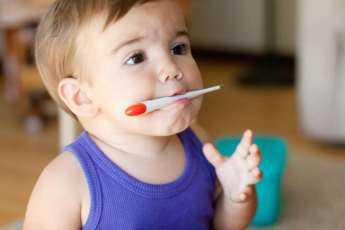 صورة لطفل يخضع لقياس حرارته