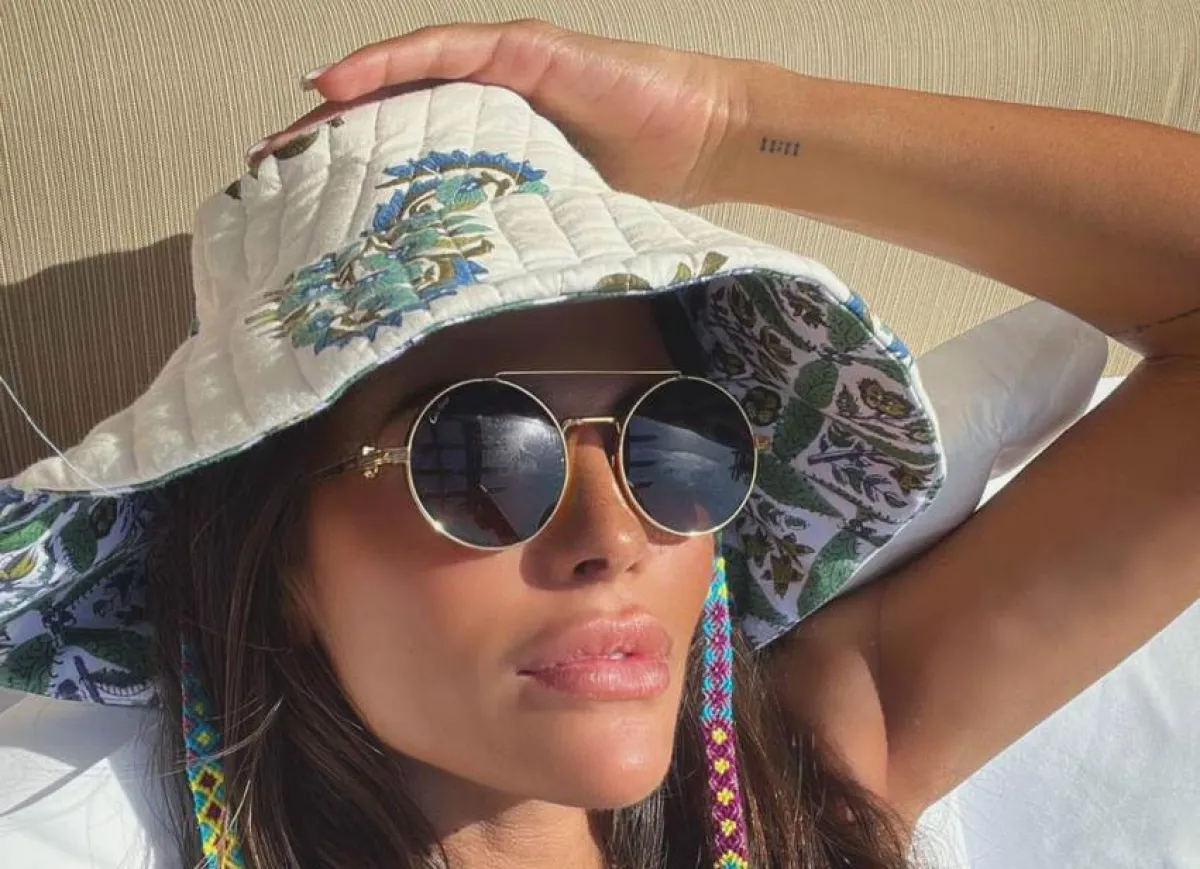 العنود بدر بنظارة شمسية دائرية وقبعة مطبعة بالورود