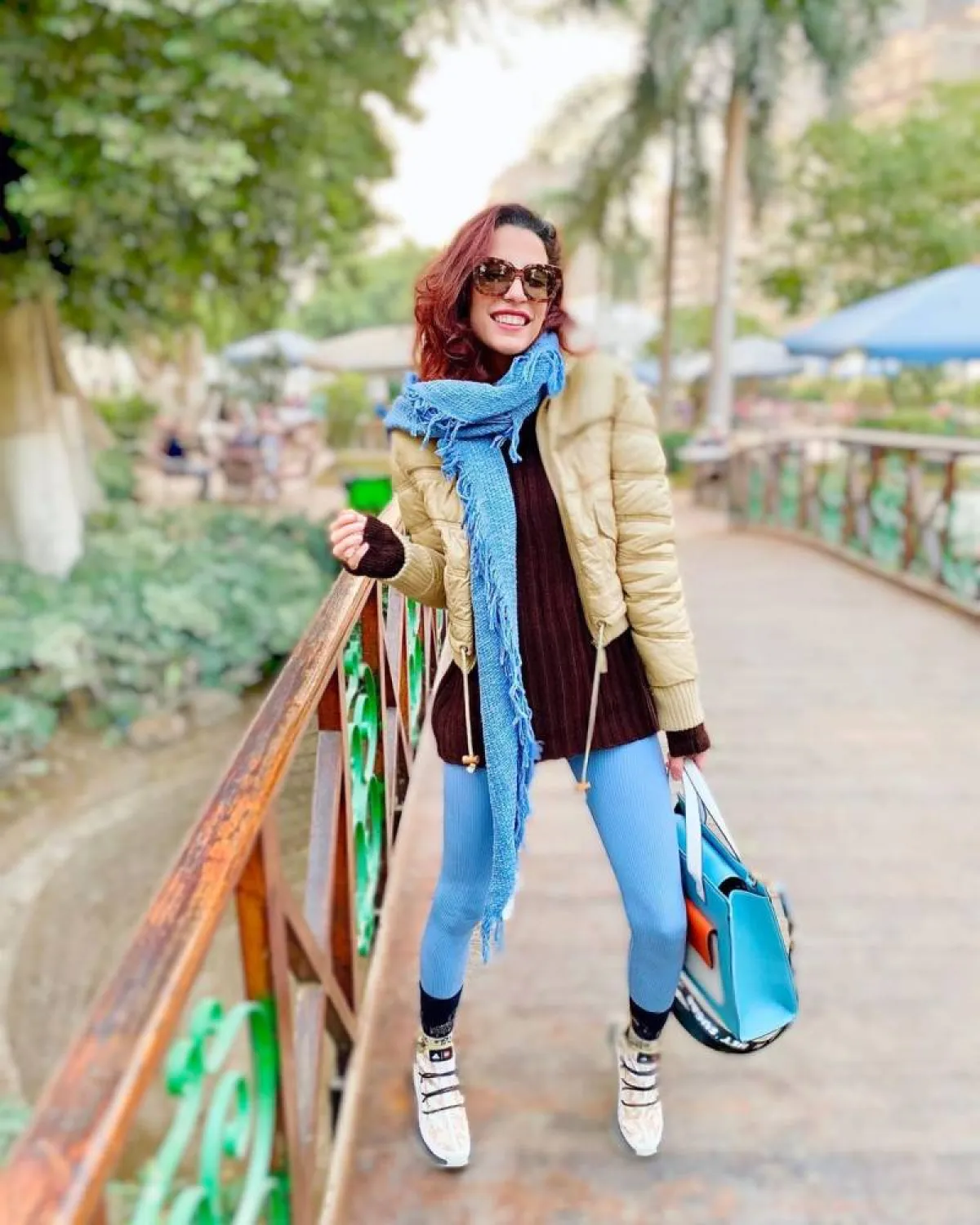 فاطمة كامل بوشاح قصير باللون الأزرق وبنطلون ضيق وجاكيت منفوخ