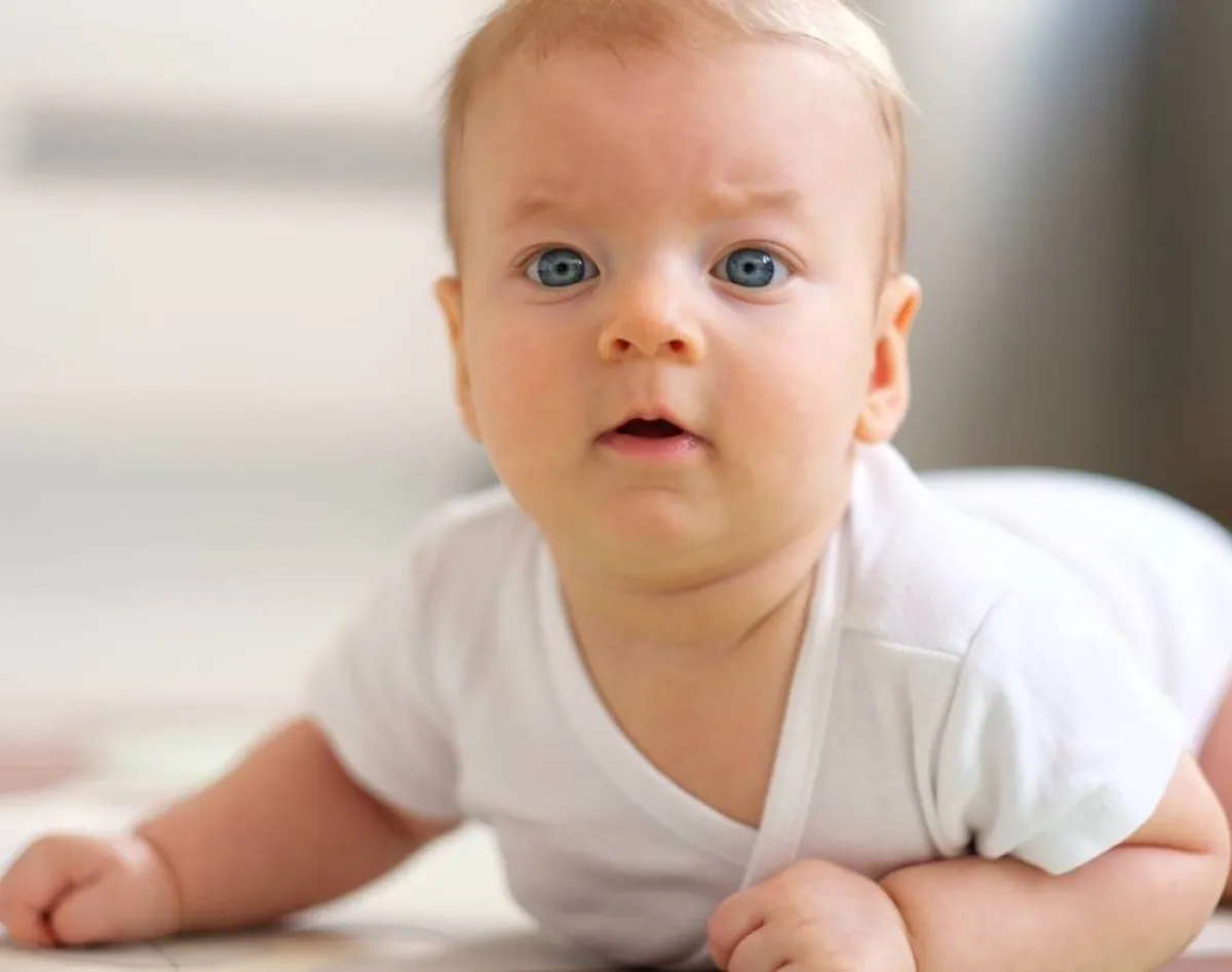 صورة لرضيع يستمتع بالنوم والتدحرج على البطن