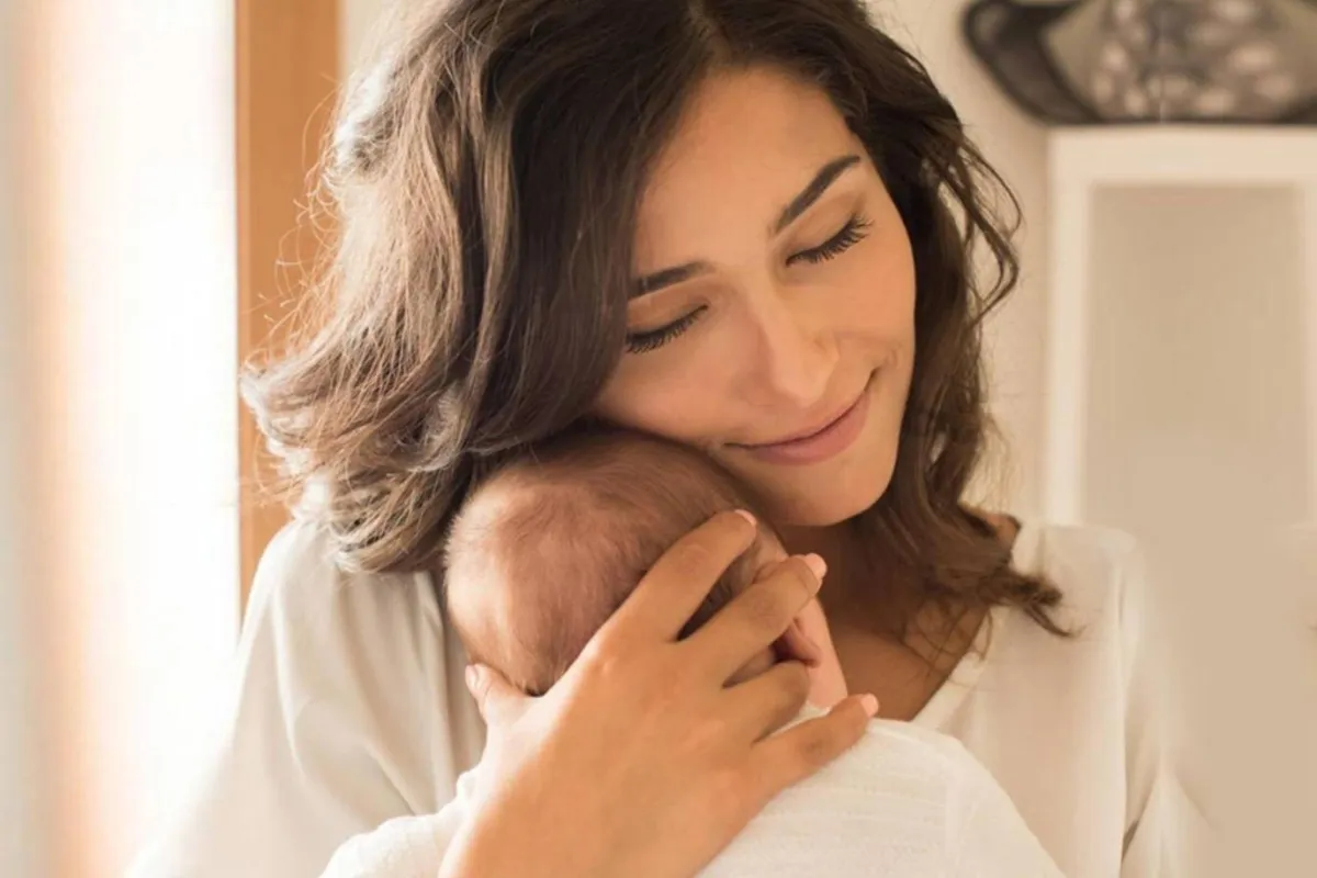 صورة لأم تحمل طفلها الرضيع