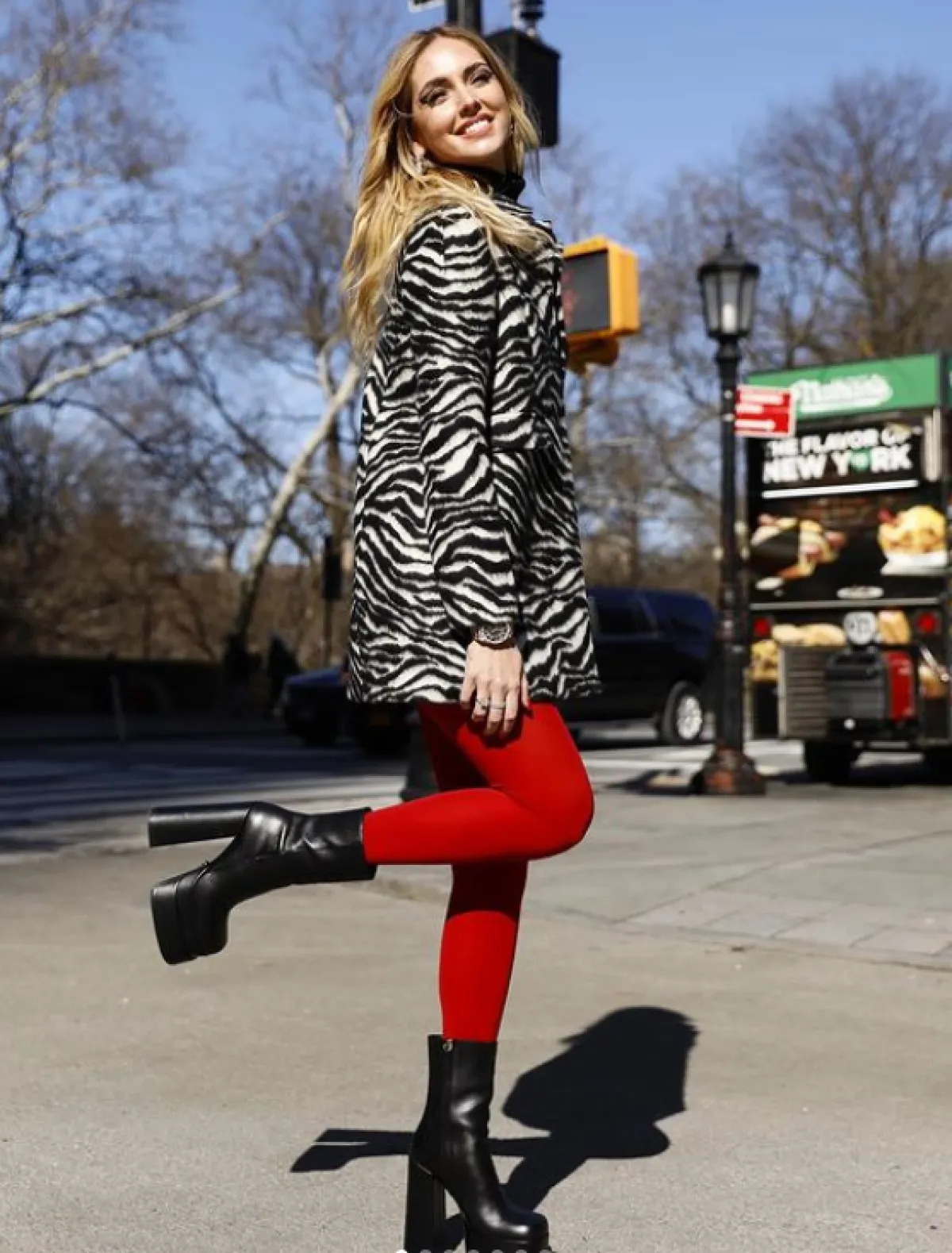 كيارا فيرانيي ترتدي بدلة مخططة مع جوارب حمراء  وجزمة سوداء 