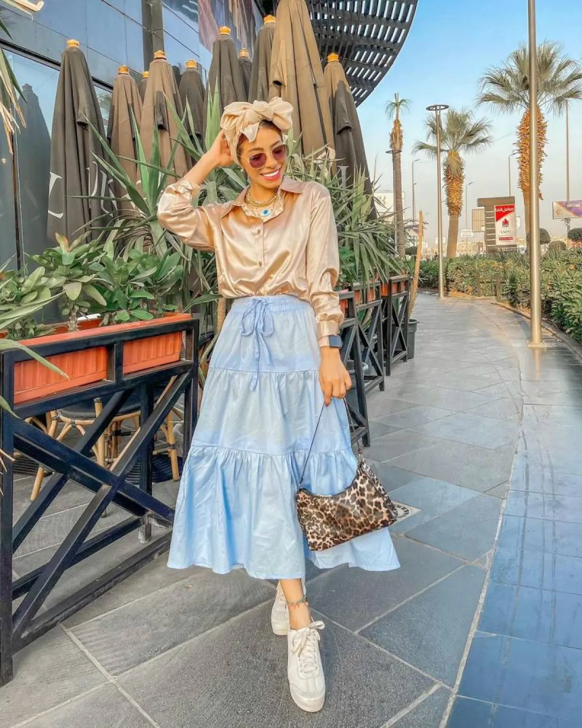 منة السني بقميص ستان ذهبي مع تنورة كشكش زرقاء