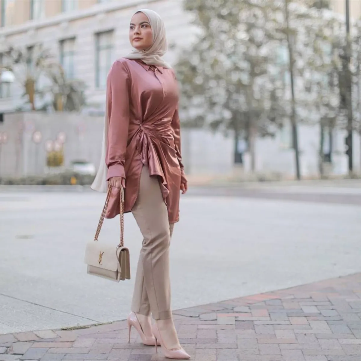 أمية زين بقميص ستان وردي داكن بتصميم الكشكش مع بنطلون بيج داكن وإيشارب بنفس اللون