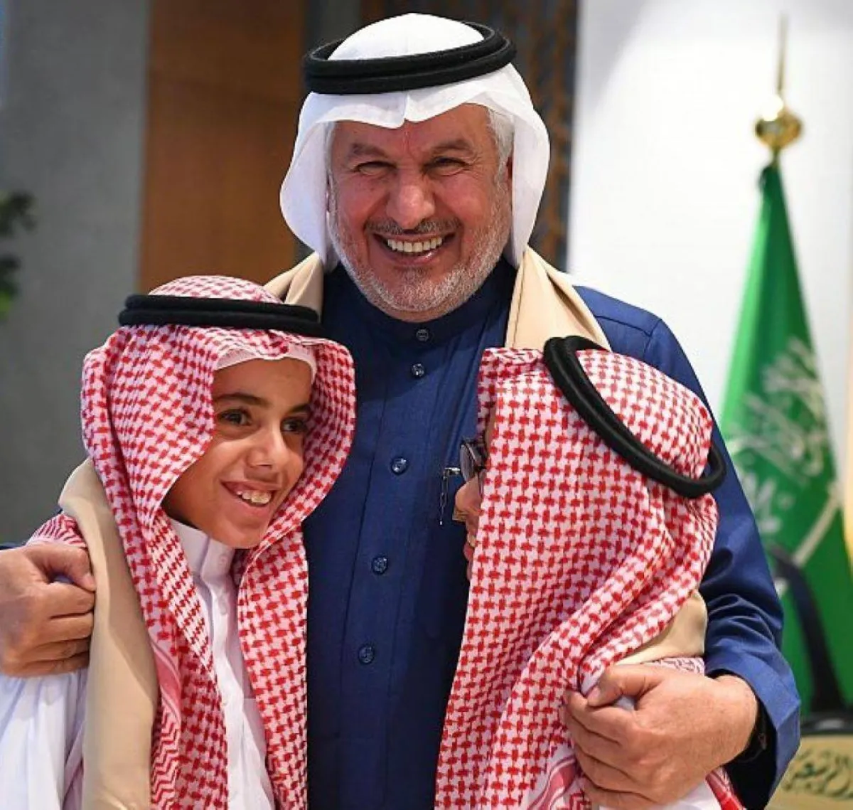 الدكتور عبدالله الربيعة مع التوأم بملابس يوم التأسيس