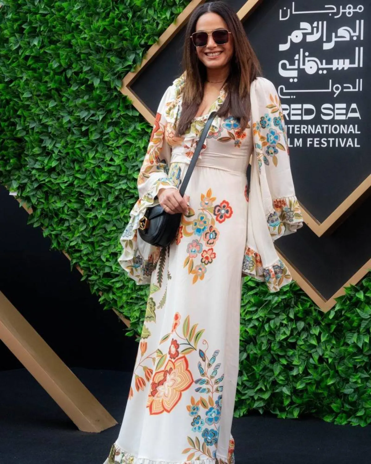 هند صبري بفستان مطبع بالورود البرتقالية والزرقاء بتصميم الكشكش على الأساور