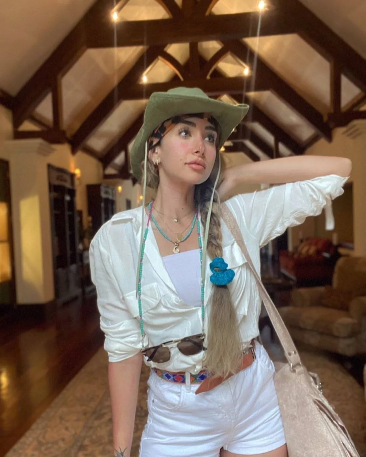 هنا الزاهد بقميص أبيض وتوب وهوت شورت باللون الأبيض وقبعة خضراء