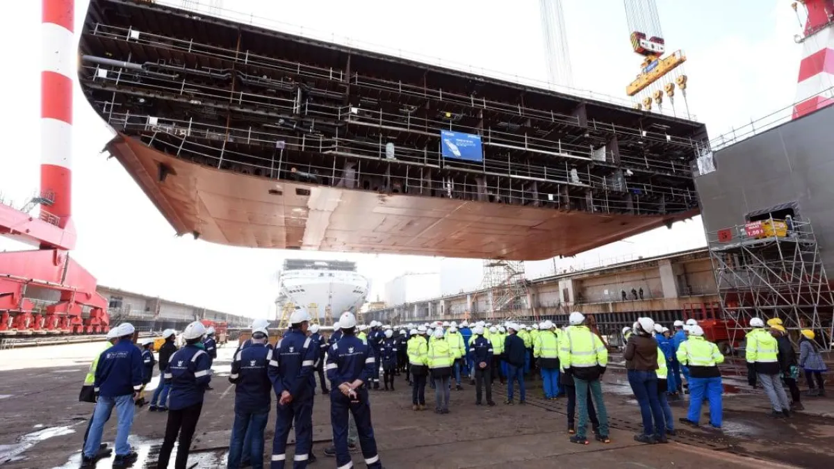 صورة عمال التصنيع والمهندسين بجانب أكبر سفينة في العالم
