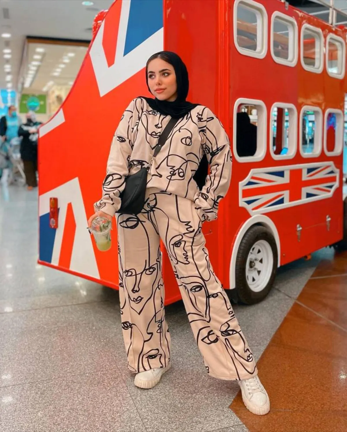 مي محمد بتيشيرت واسع باللون البيج مع رسوم سوداء وبنطلون واسع هاي ويست بنفس اللون