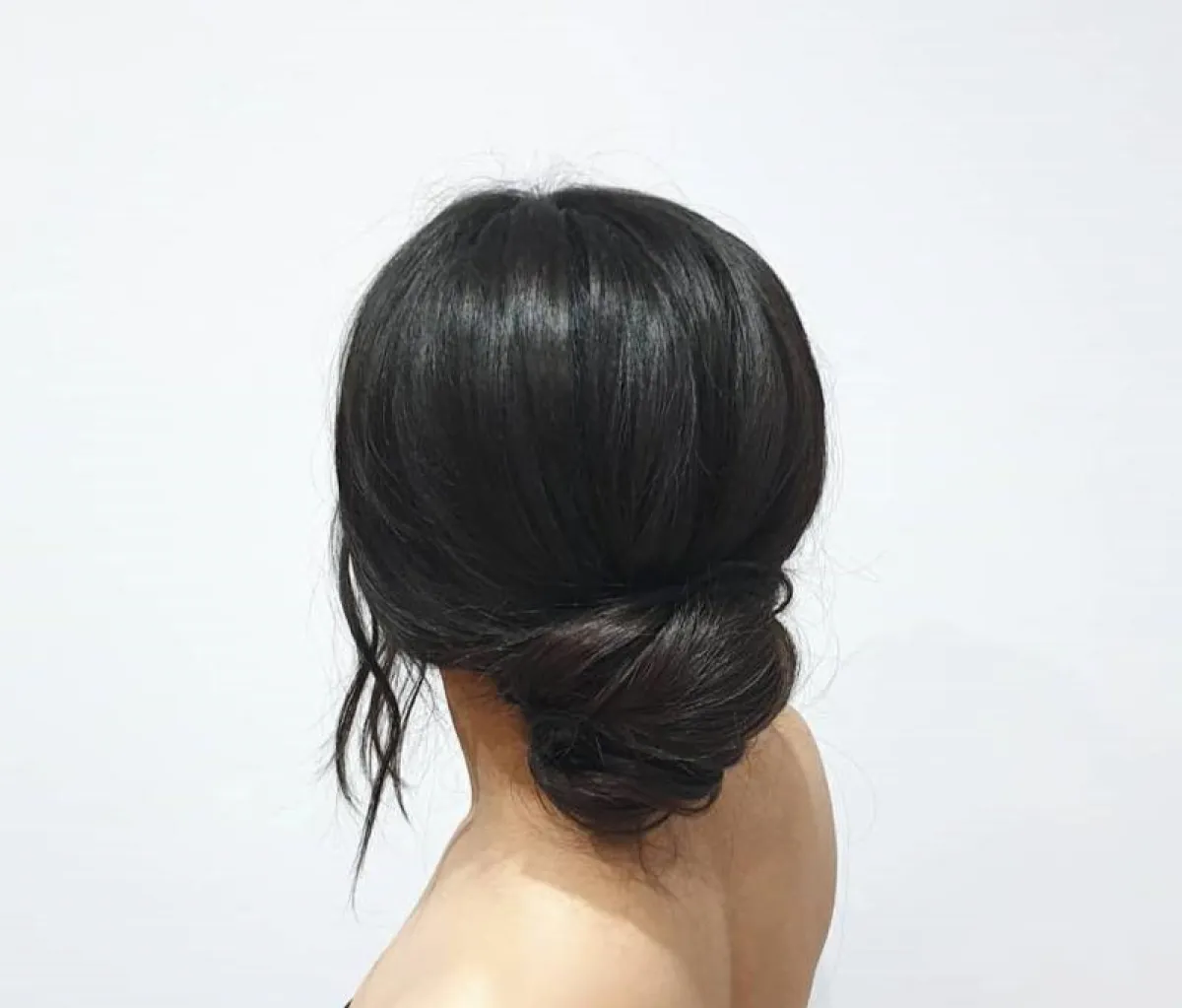 تسريحة كعكة منخفضة مع خصلات على جانبي الوجه للشعر المالس