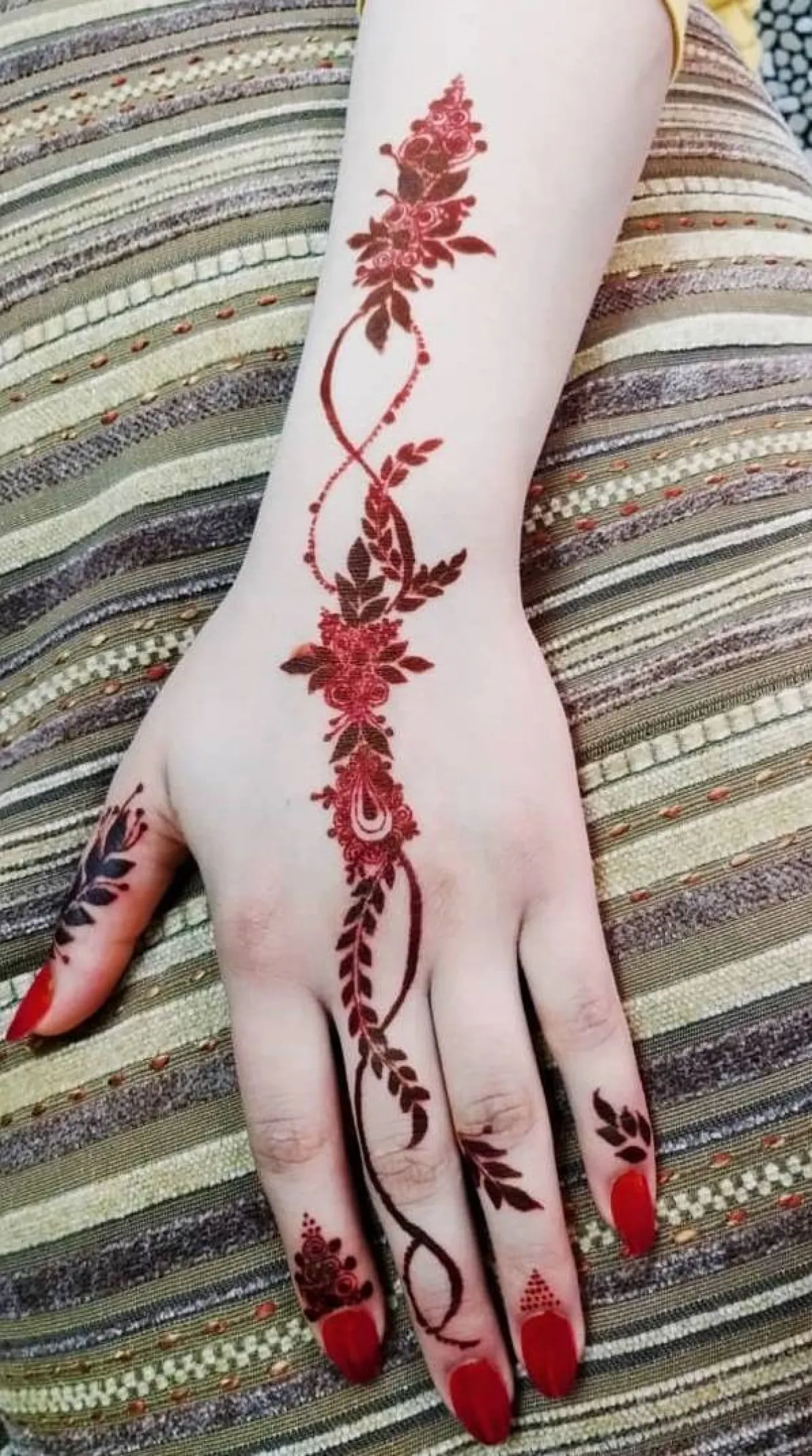 نقش خناء بورود وفروع أشجار حمراء للعروس الخليجية الجريئة