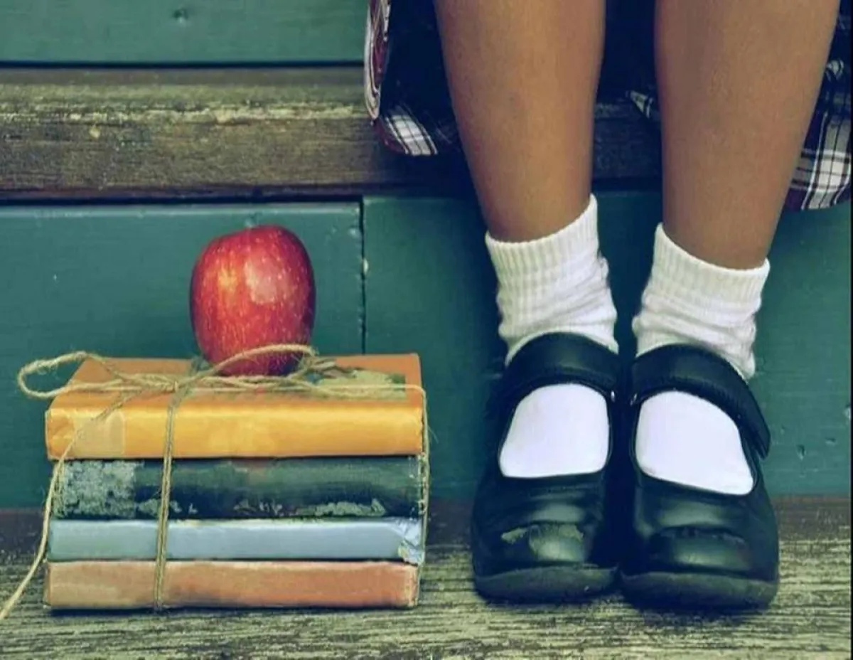 صورة لطفلة ترتدي حذاء مدرسة باللون الأسود