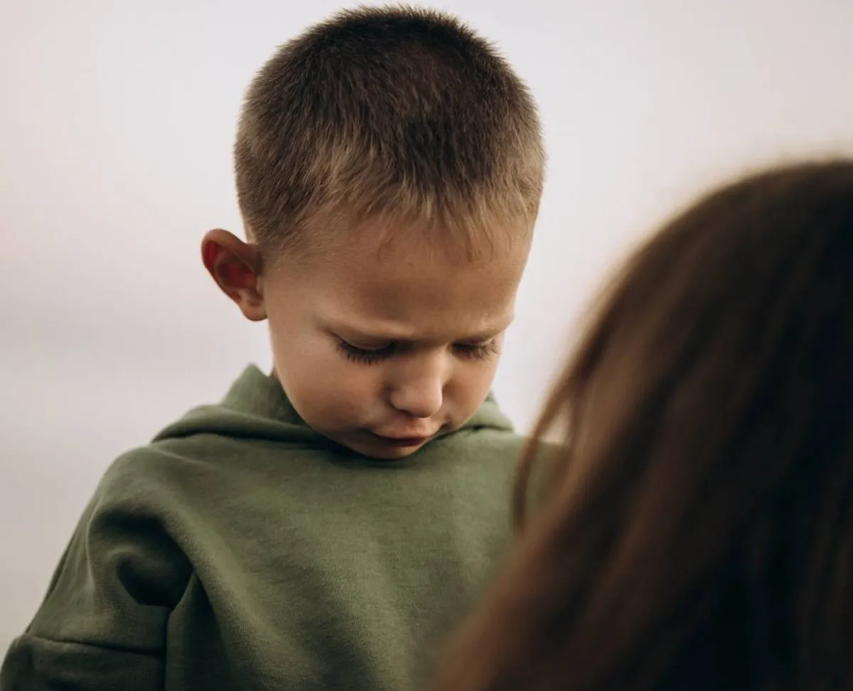 صورة لطفل تبدو عليه علامات الضيق من سيطرة الأم