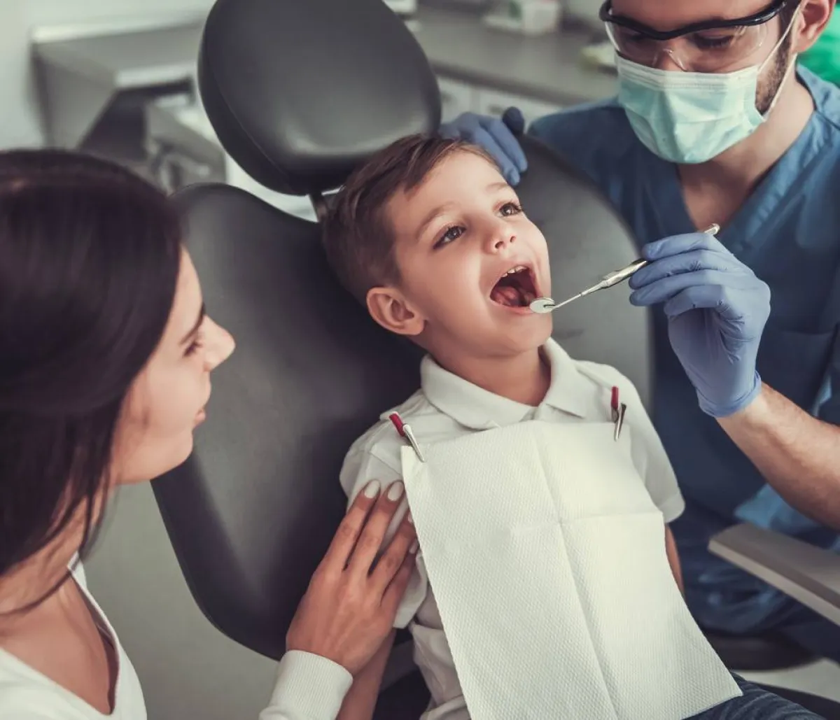 صورة لطبيب اسنان يفحص الطفل