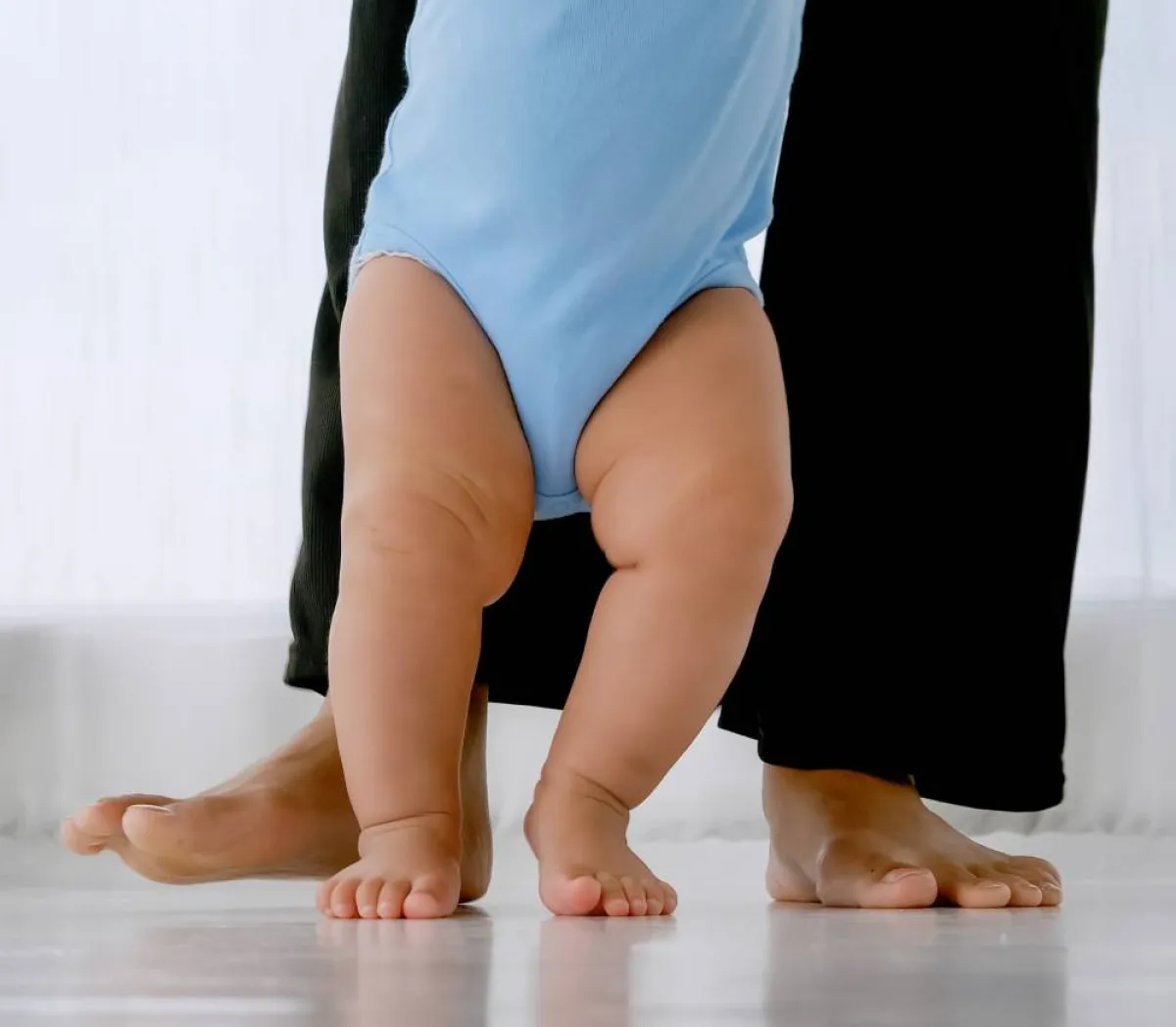 صورة لطفل يمشي بمساعدة والدته