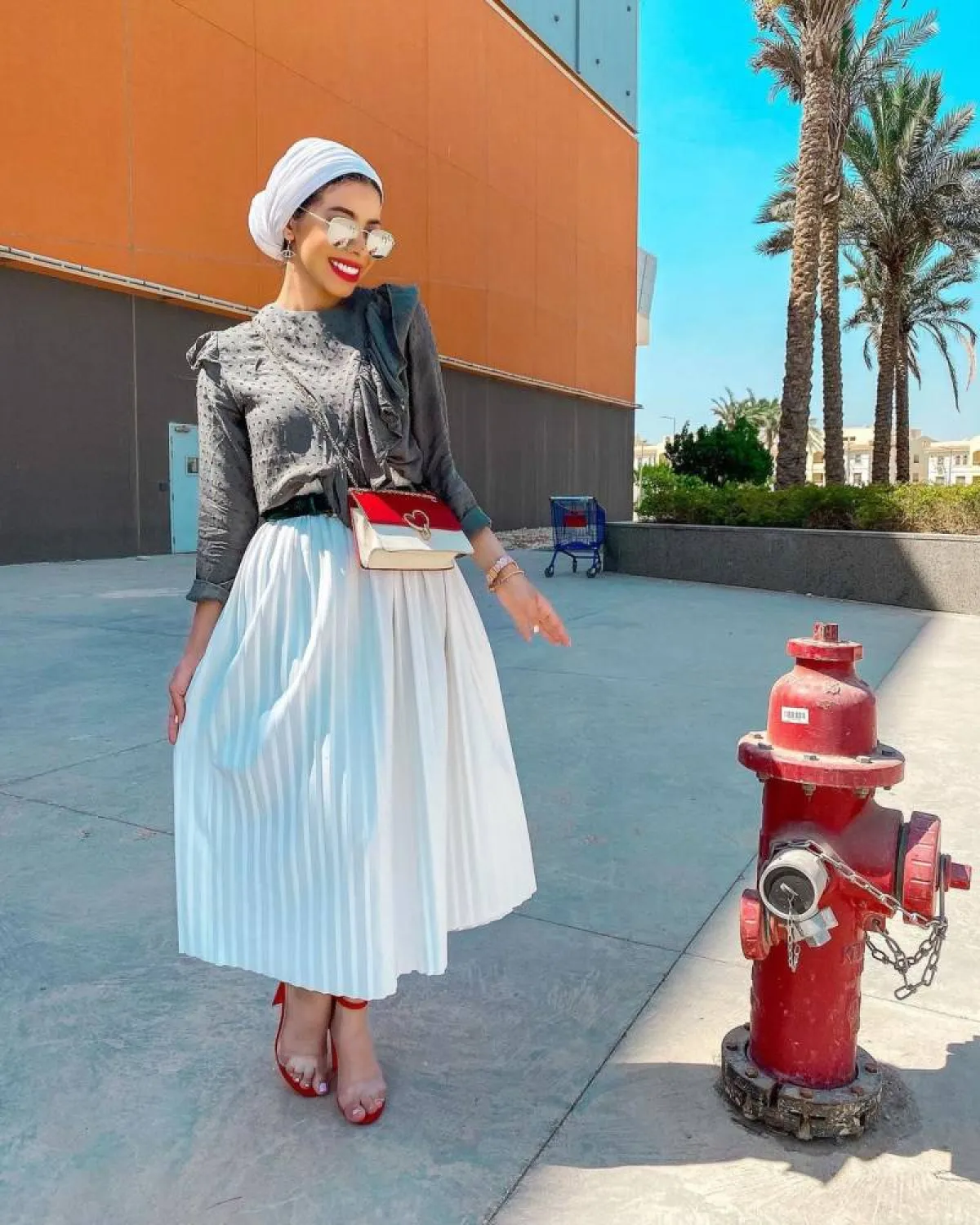 منة السُني بتنورة بيضاء وحذاء أحمر