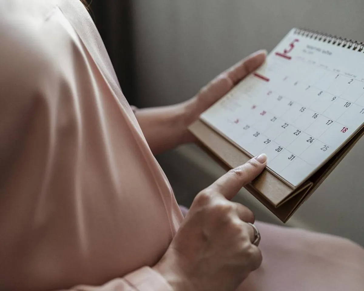 صورة لحامل تقوم بحساب عمر الحمل