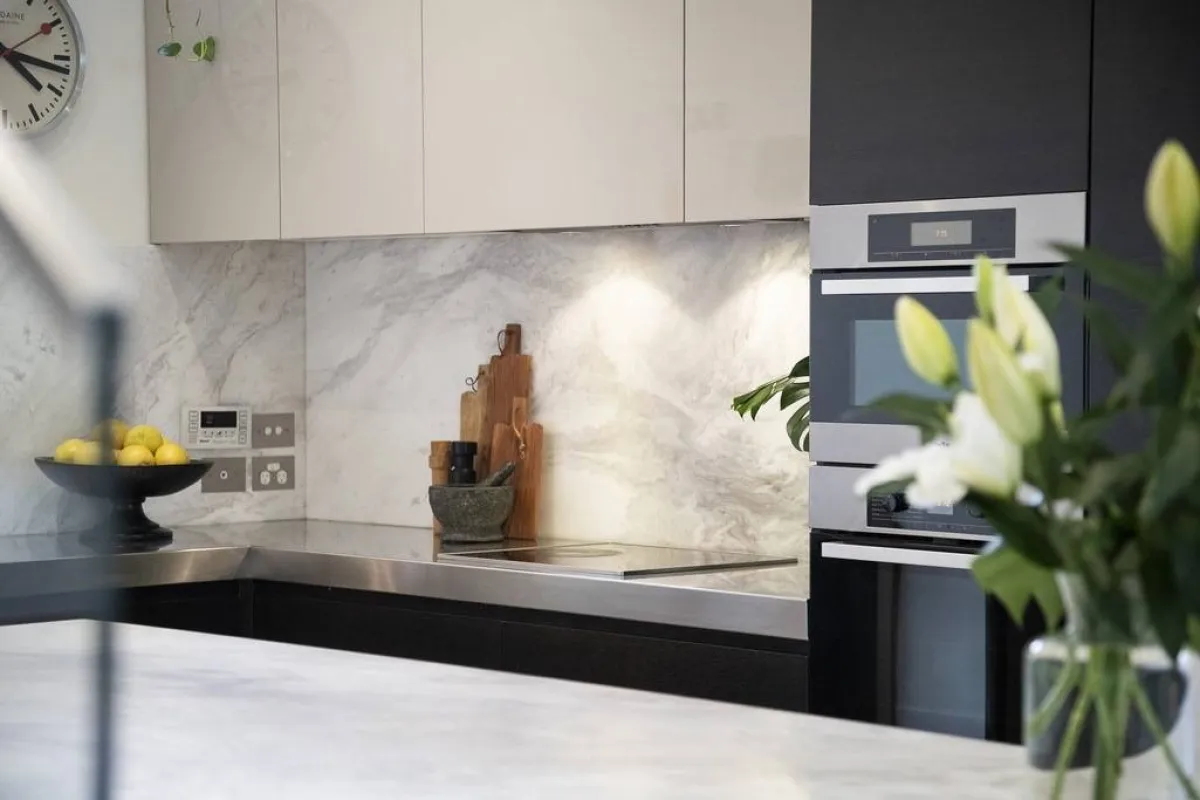 السيراميك يبدو في المطبخ، في المساحة الفاصلة بين سطح المجلى والخزائن العلويّة 