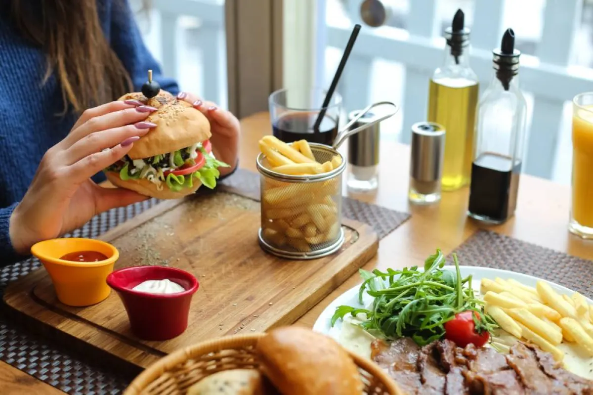 صورة لسيدة حامل تأكل وجبة سريعة فقيرة بالحديد