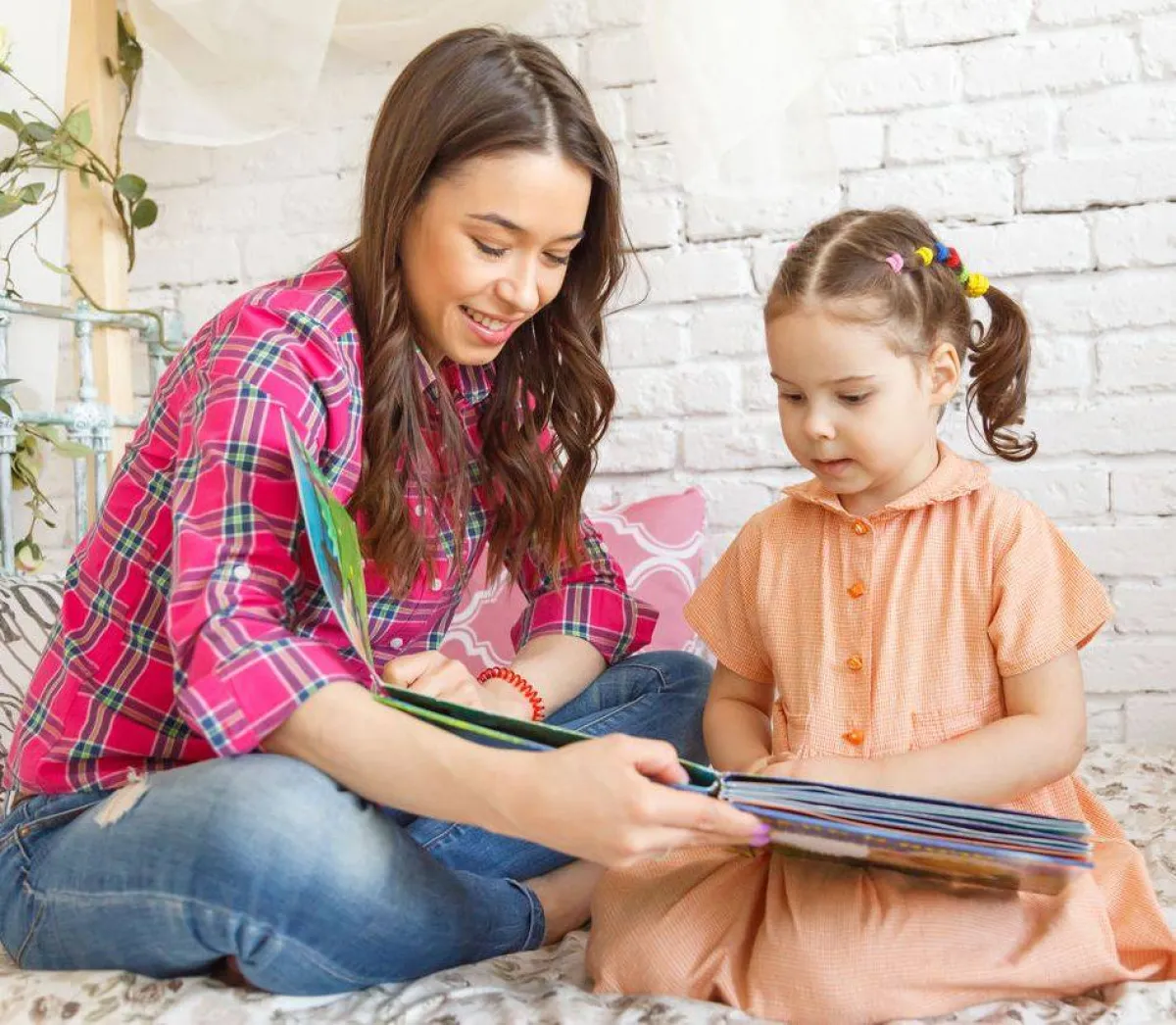 صورة الأم تقرأ لطفلتها