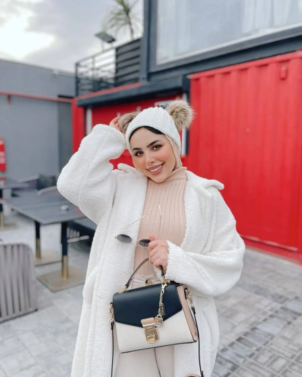 مي محمد بمعطف فرو مع هاي كول بيج وبنطلون أوف وايت