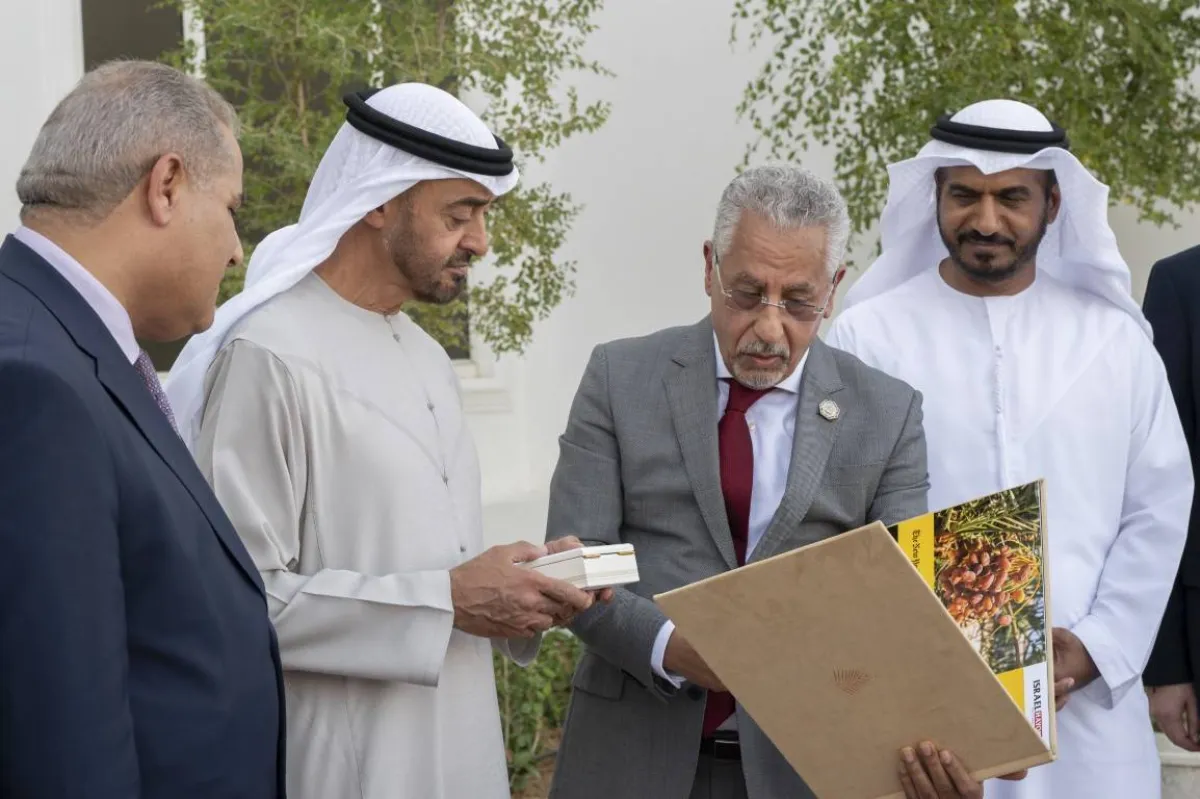 رئيس الوفد يهدي الشيخ محمد بن زايد أحدث إصدارات الجائزة. الصورة من "وام"