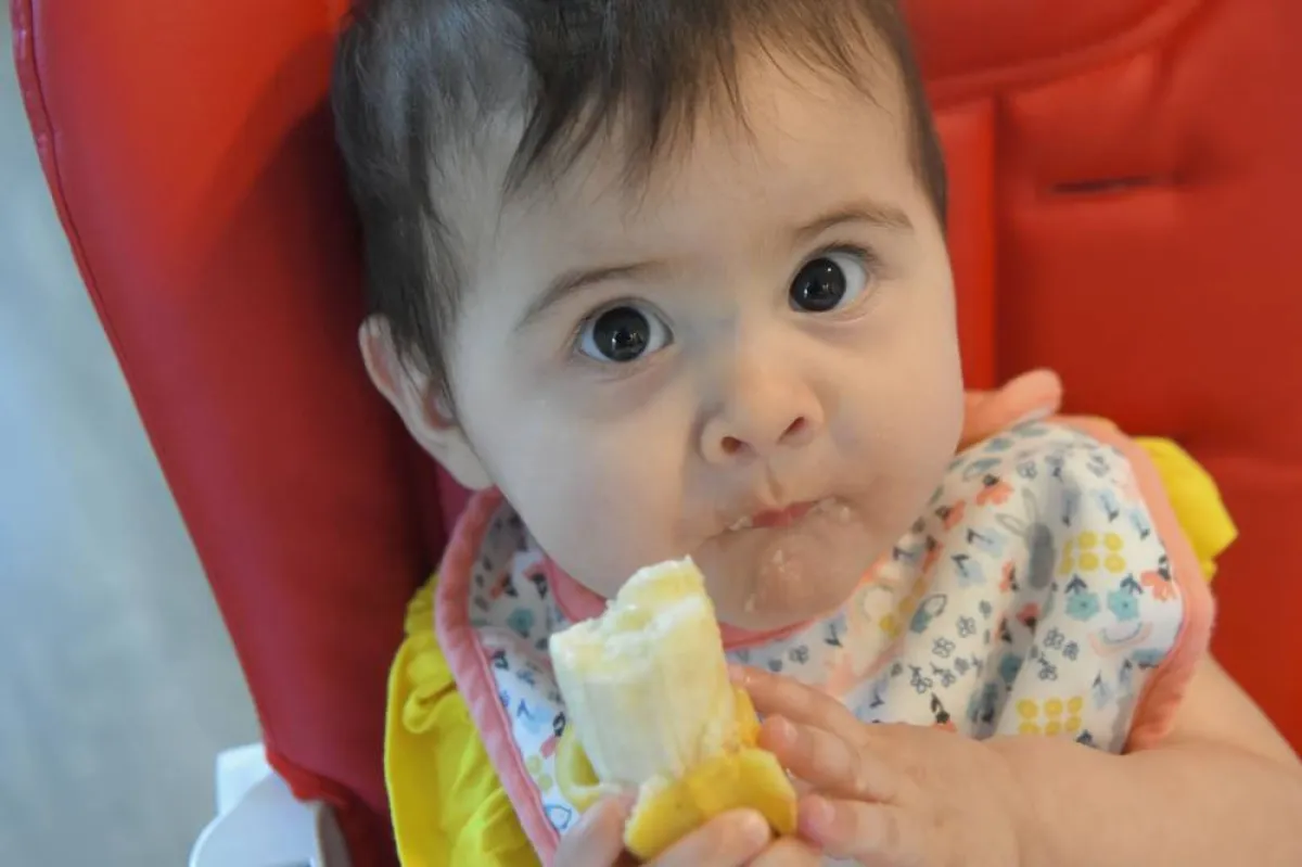 صورة طفل يأكل موزة