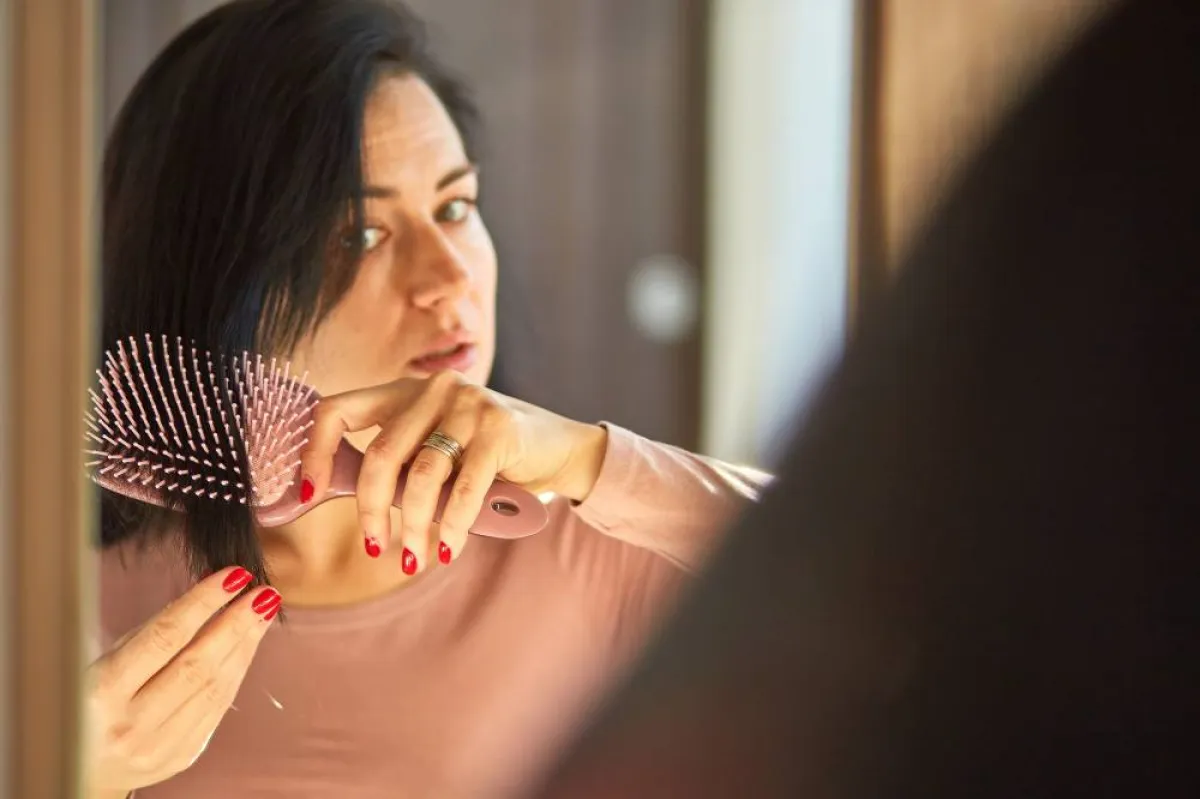صورة لامرأة تمشط شعرها