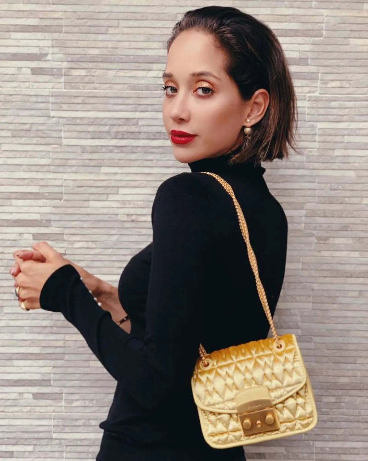 لانا الساحلي بحقيبة كتف ذهبية 