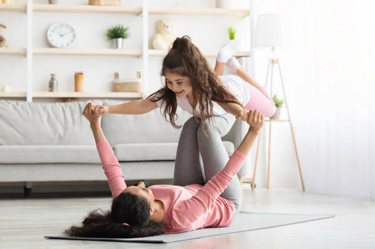 صورة لأم تمارس االرياضة مع طفلتها