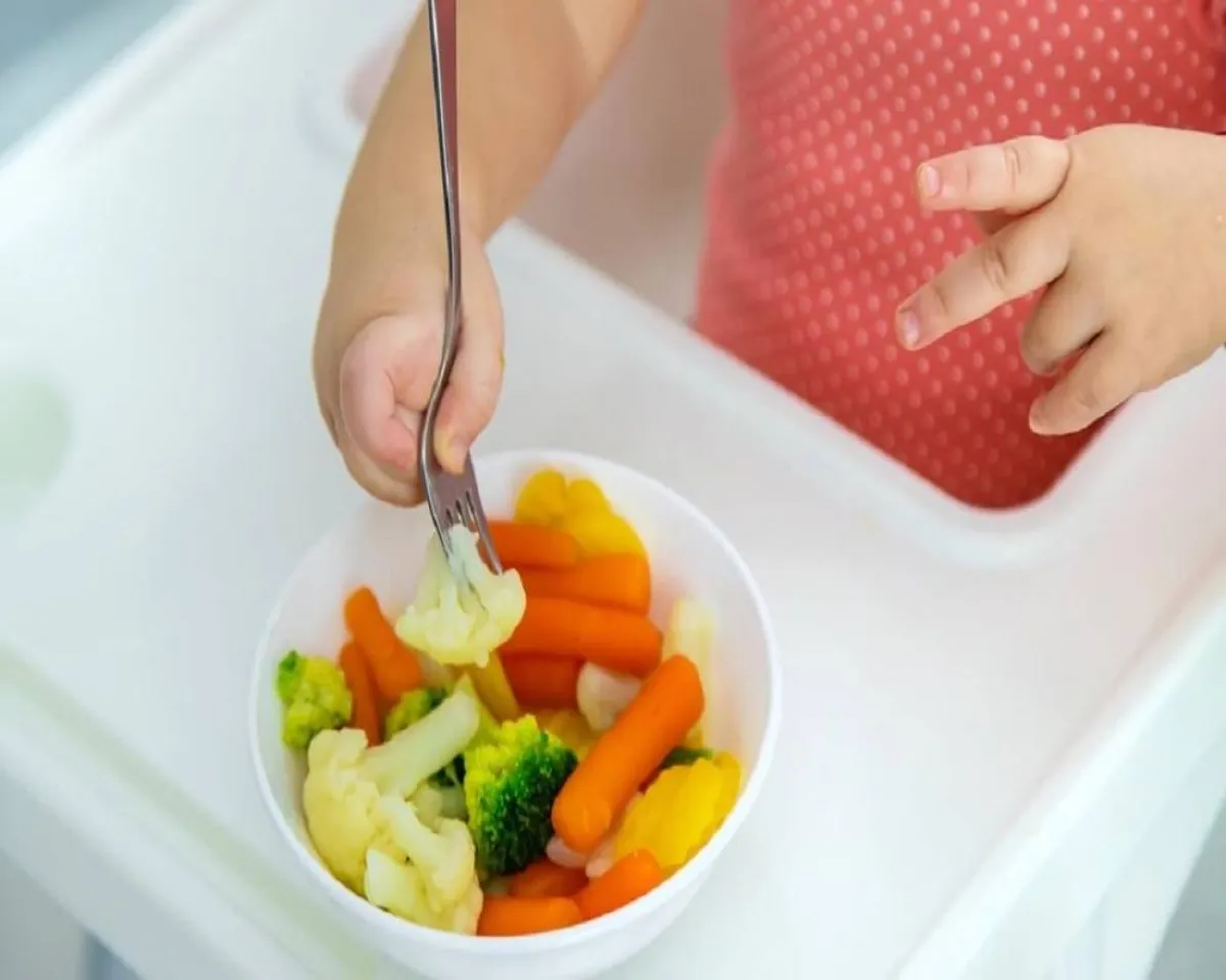 صورة لطفلة تتناول الخضروات وبذور الذرة