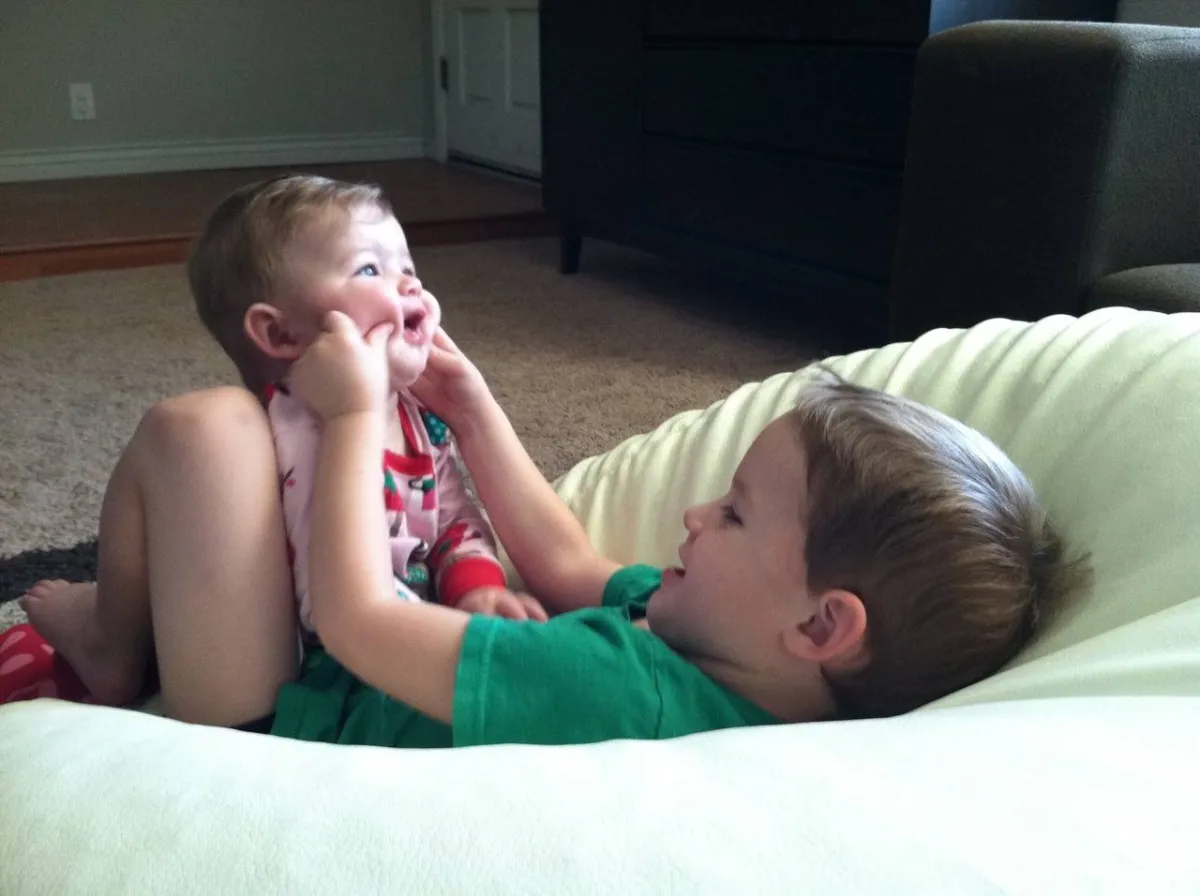 صورة لأخ يقرص خدي أخيه الأصغر