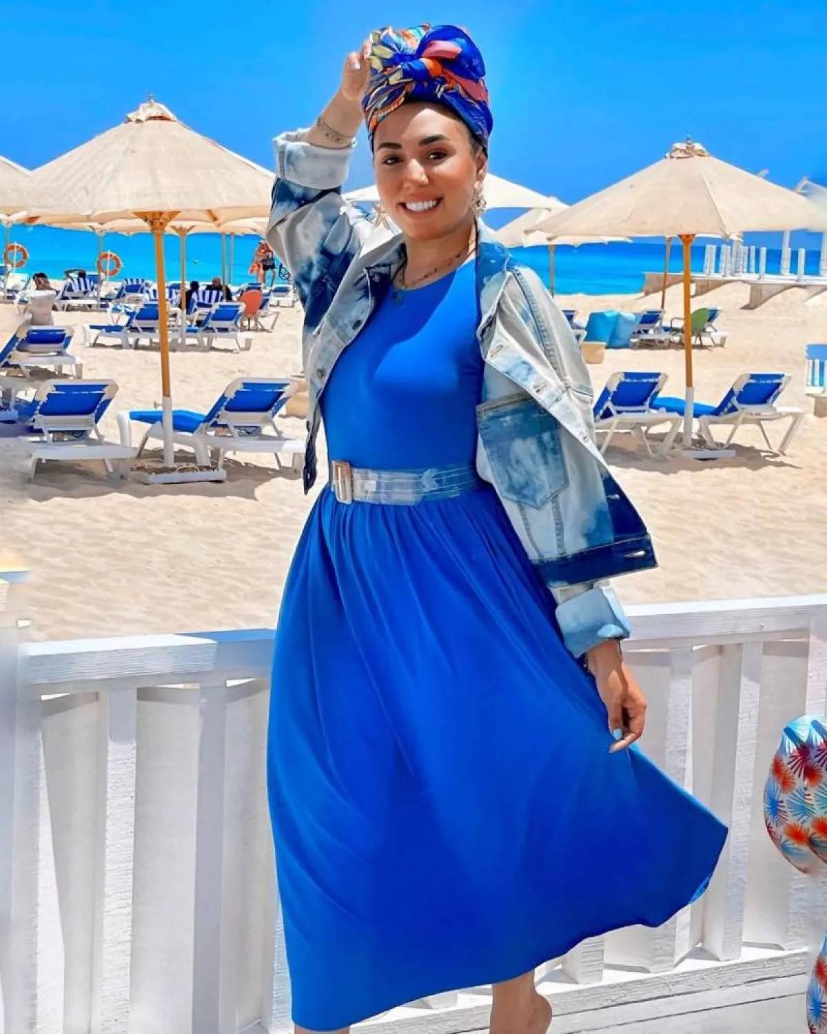 مي إبراهيم بفستان كلوش طويل أزق وتربون باللونين الأزرق والبرتقالي