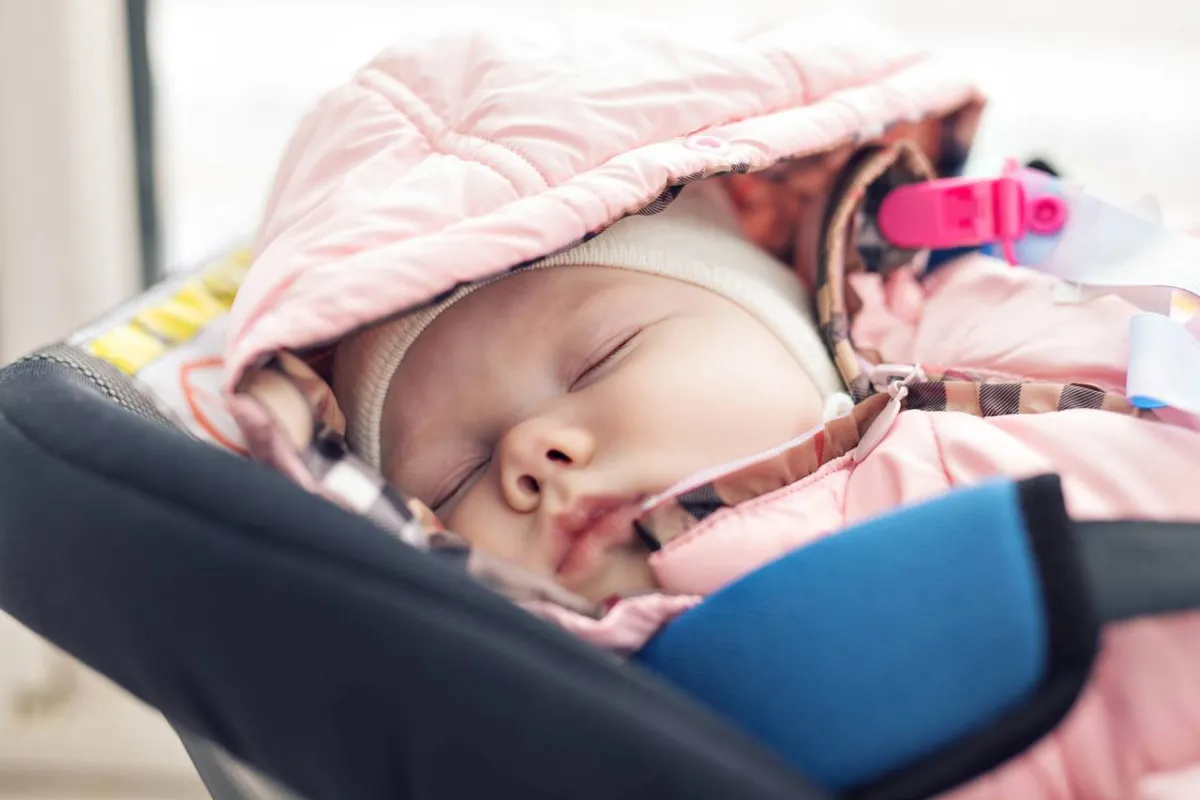 صورة طفل نائم في مقعد السيارة