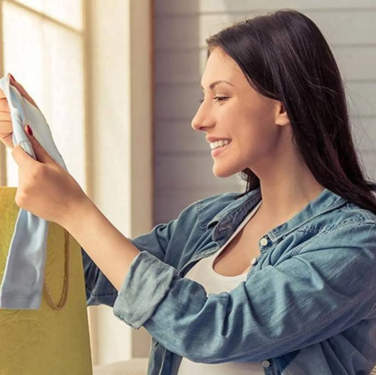 حامل فرحة بملابس المولود