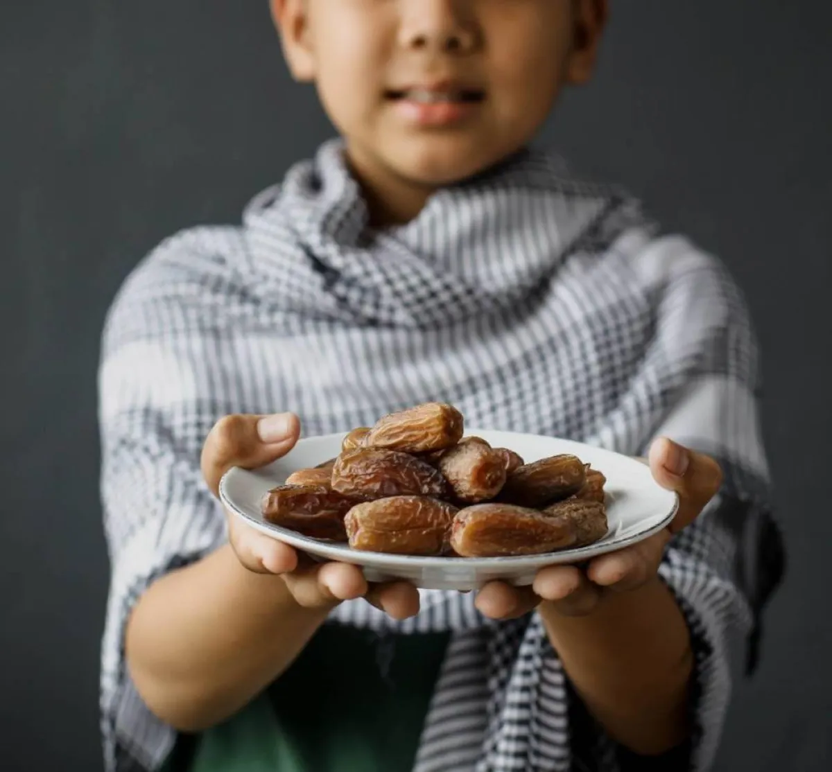 صورة لطفل يقدم التمر خلال رمضان