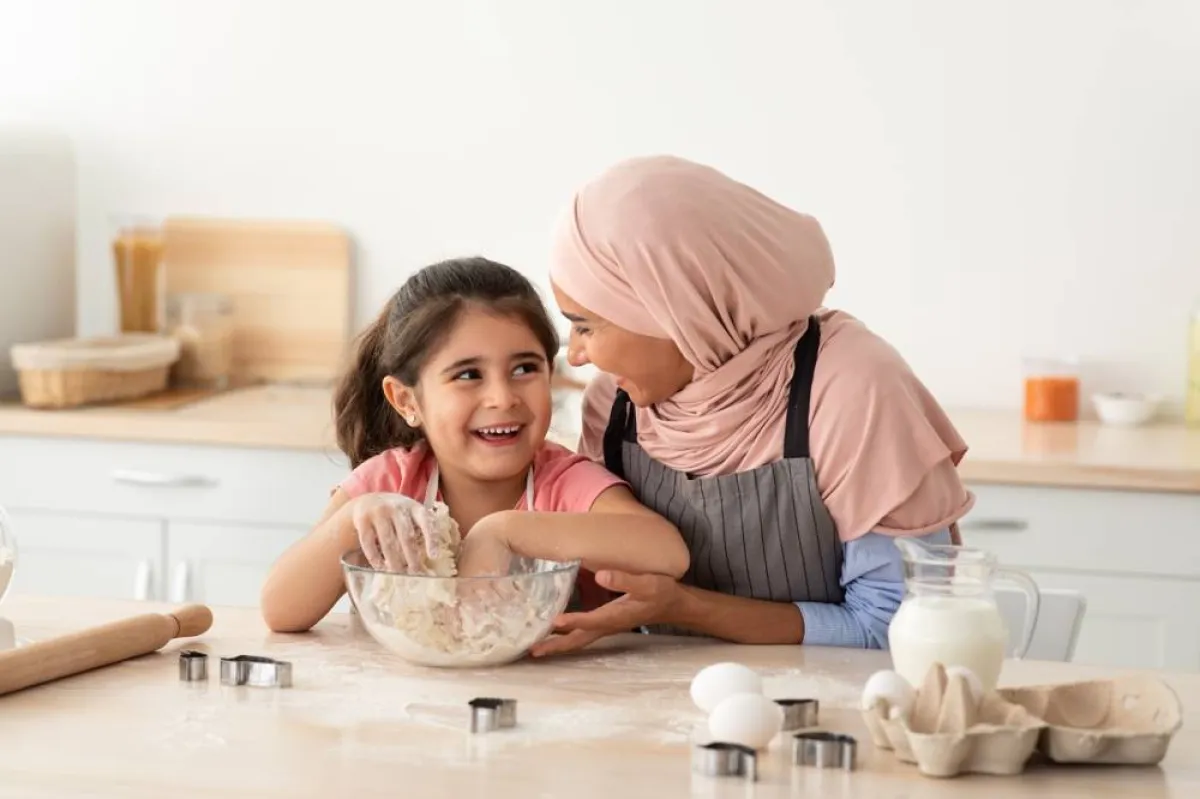 صورة لأم تدخل طفلتها المطبخ في رمضان