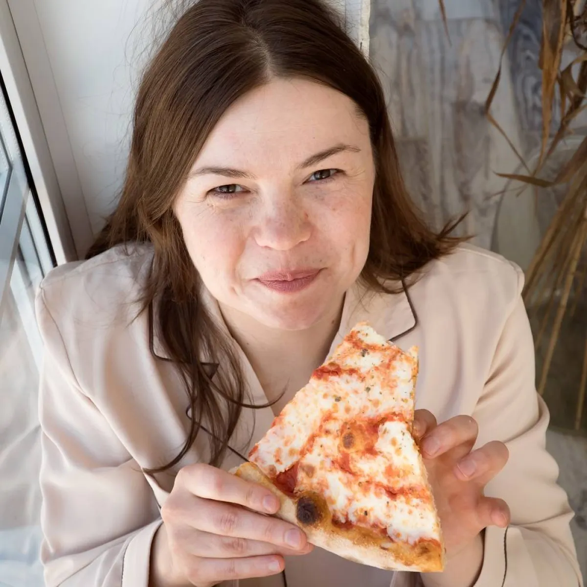 صورة لحامل تتناول البيتزا