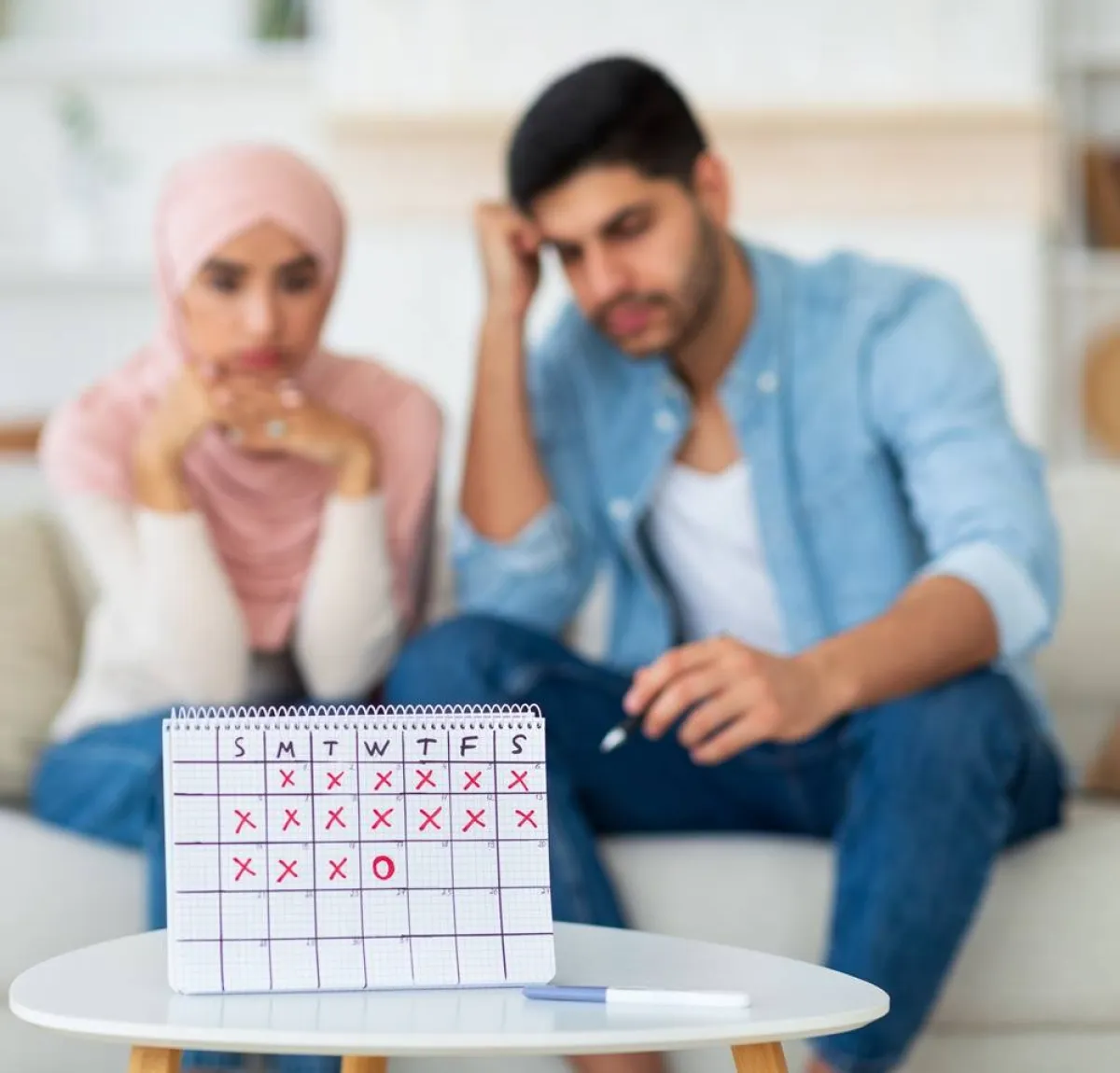 صورة لزوجين يتابعان جدول أيام الحمل